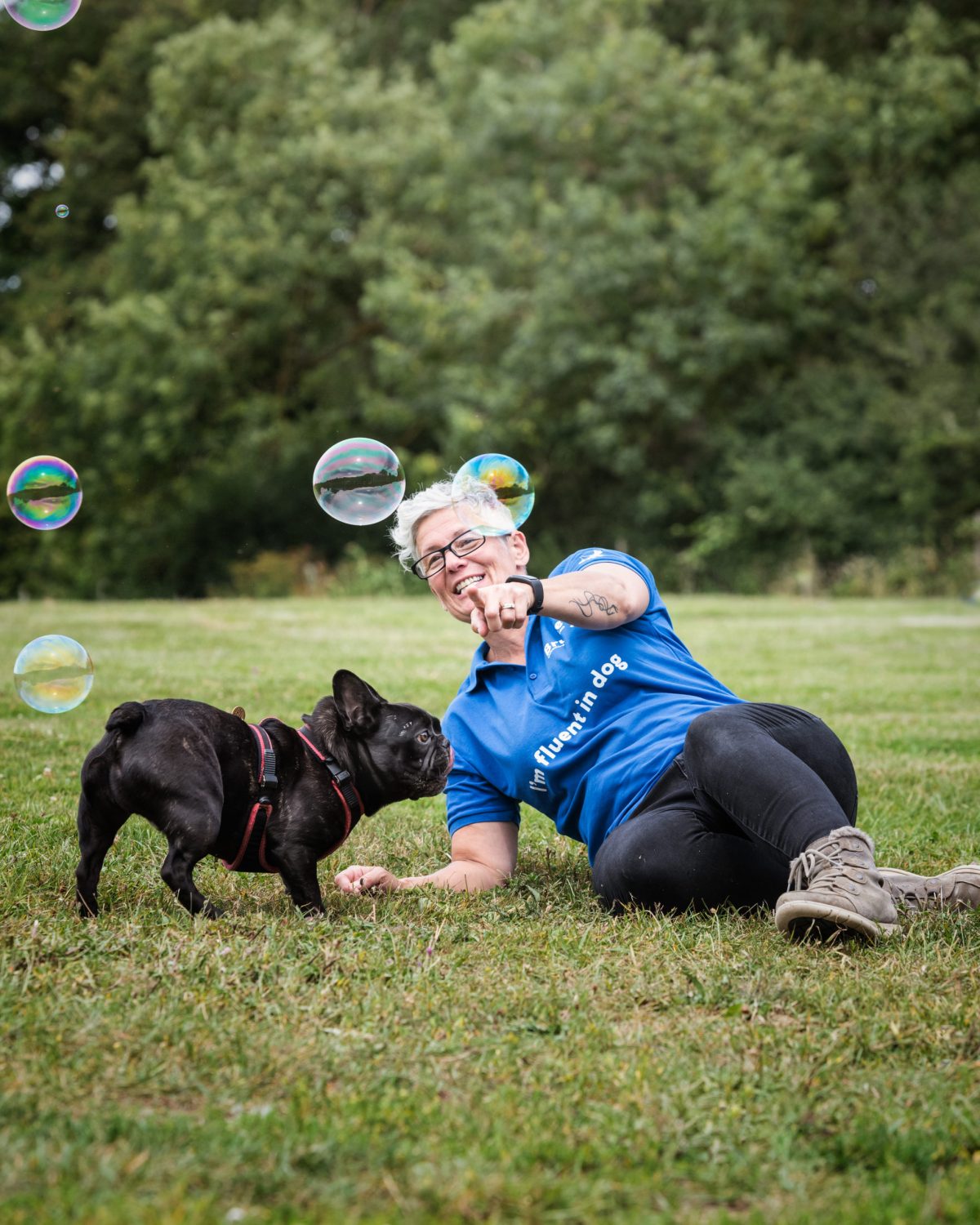 Dog carer playing with a french bulldog and bubbles