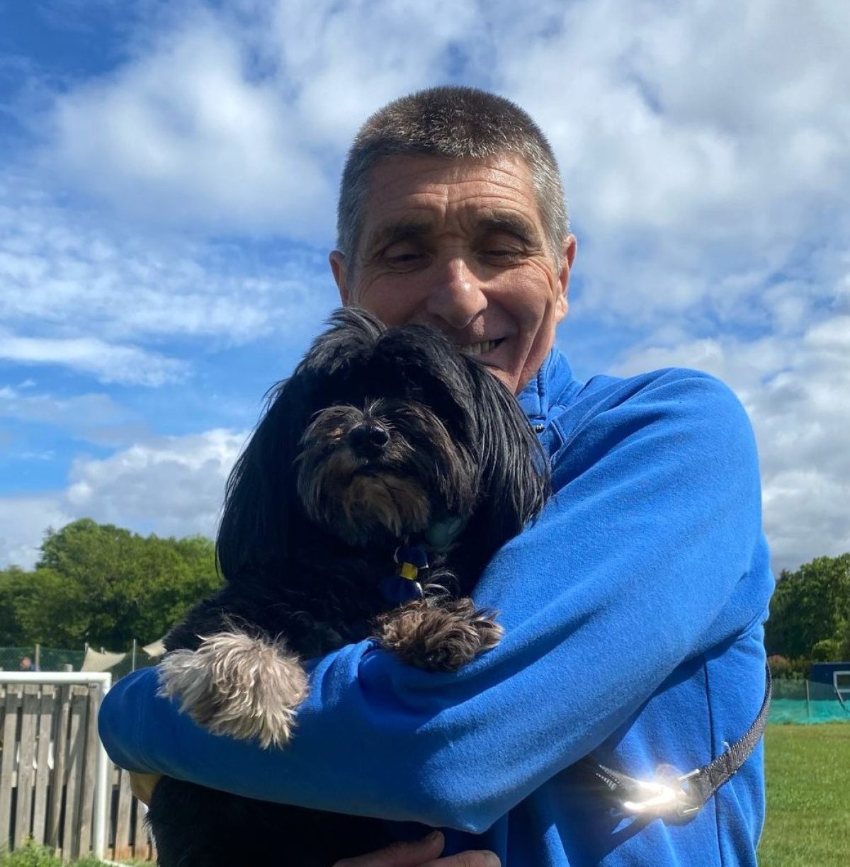 Bruce's carer cuddling dog in arms